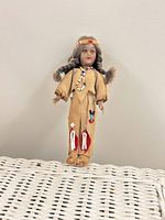 Front view of doll standing on wicker surface