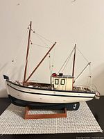 Starboard side view of wooden fishing boat model on stand