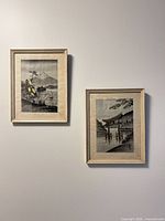 Both framed silk thread artworks hanging on wall