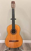 Full front view of Kiso Suzuki classical guitar on stand