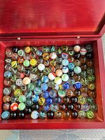 Wide view of open wooden box showing entire assortment of marbles