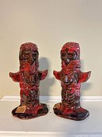 Front view of two glazed ceramic totem poles