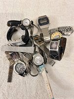 Pile of assorted wristwatches and bracelets