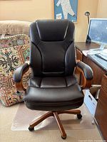 Front view of brown leather desk chair showing seat, backrest, padded arms, and casters