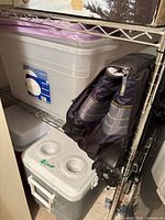Rubbermaid cooler, storage bins, folded rolling cooler on shelf