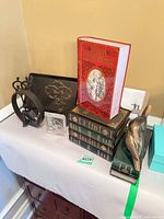 Overall lot showing cast iron pieces, faux book boxes, glass book decor, bird bookends
