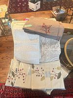 Stack of placemats and assorted runners showing designs and colors