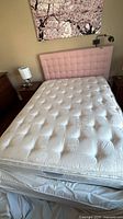 Double mattress on bed frame showing tufted quilt surface