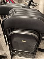 Stack of black metal folding chairs
