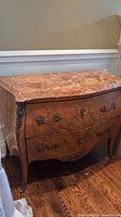 Full view of bombe chest showing marble top, wood finish and hardware