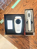 Boxed Nood IPL handset and boxed LED hair brush side by side