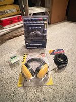 Group shot of all four packaged items: bit set, earmuffs, cable lock, nail box