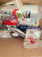 Box showing Bennett plastic drop cloth roll and assorted hardware items