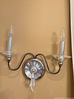 Full view of one Jasmine polished silver wall sconce mounted on wall