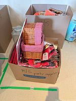 Box containing wicker baskets, red gingham disposable items