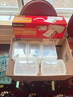 Box containing laminator and six clear storage boxes