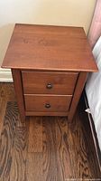 front view of brown solid wood nightstand with two drawers