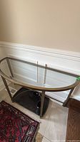 Front view of demilune console table showing glass top and metal frame