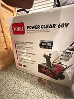 Sealed box showing Toro Power Clear 60V cordless single-stage snow blower graphic