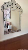 Front view of Venetian etched glass wall mirror mounted on wall