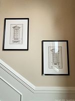 Both framed prints displayed on wall