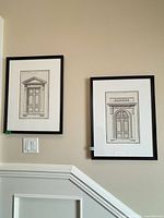 Both framed prints hung on wall