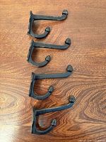 four black cast iron hooks top view