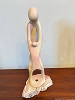 Front view of abstract stone sculpture showing parent and child form on stone base