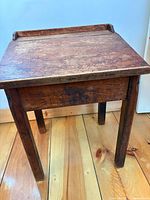 Desk front view showing top, legs, raised back lip