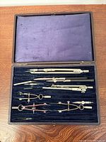 Open case showing all drafting instruments in velvet tray
