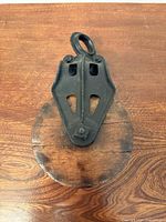 Front view showing cast iron frame and eye plus wooden wheel