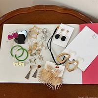All earrings laid out on white board showing variety and count