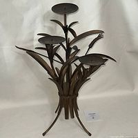 Full view of metal wheat sheaf candelabra standing upright
