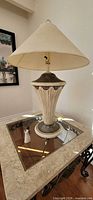 Full view of beige ceramic table lamp with fabric shade on table