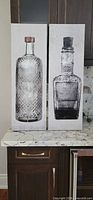 Front view showing both bottle canvas prints side by side