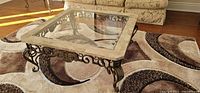 Full view of square coffee table showing glass top and marble border