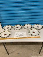 Overview of six Christmas themed plates on table with ruler