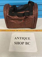 Front angle of brown faux croc pet carrier with ruler for scale