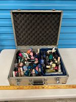 Open aluminum case showing large quantity of nail polish bottles