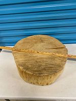 Full view of round wood slab with measuring stick across top showing diameter