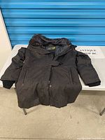 Full view of jacket laid flat showing overall design, length, hood and closure