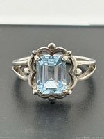 Front view of sterling silver ring with emerald-cut sky blue topaz