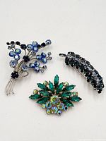 All three brooches showing designs and stone colours