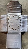 Necklace laid inside opened satin case