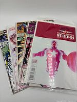 Stack of five bagged Marvel comics fanned out showing various titles