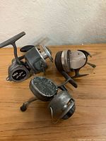 All three vintage fishing reels on table