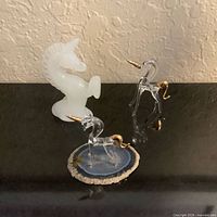 Three unicorn figurines: white glass, clear on agate, clear freestanding