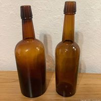 Front view of both amber whiskey bottles upright