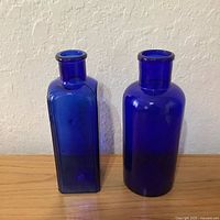 Square and round cobalt blue bottles front view