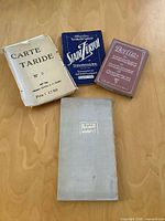 Four map/postcard folders laid out: Carte Taride Paris, Stadt Zürich, Berlin folder, Roma e Dintorni canvas map cover